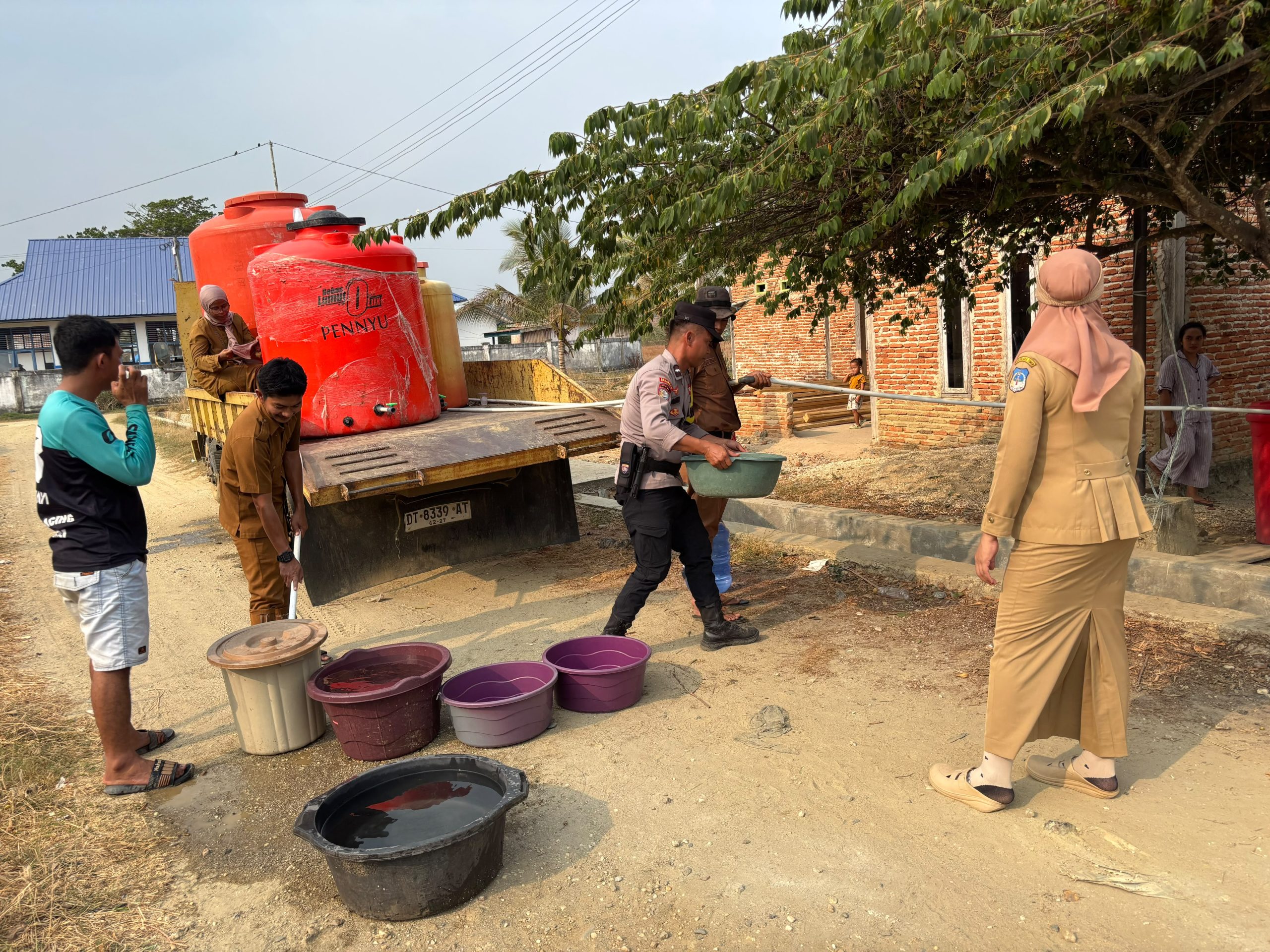 Bhabinkamtbmas Aipda Ardi bersama Pemerintah Desa Bou menyalurkan air bersih ke puluhan warga. Foto : Humas Polres Kolaka Timur